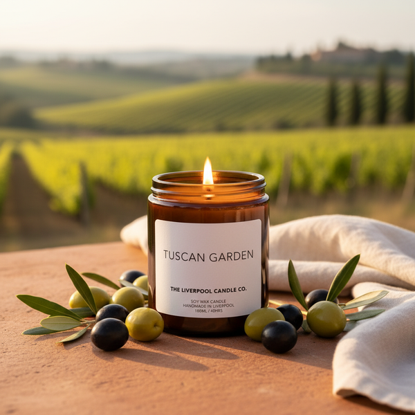 Tuscan Garden soy wax candle in amber jar with olives and olive branches on terracotta surface